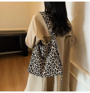Detailed view of leopard print tote bag styled with a beige trench coat for autumn
