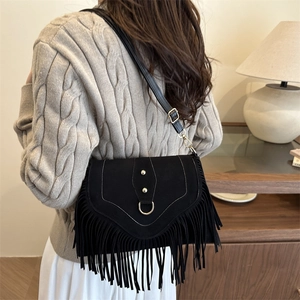 Sacoche vintage en suédine noire avec franges et rivets porté par un mannequin