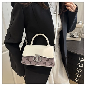Close-up of contrast leather handbag with logo print, silver buckle, and shoulder strap