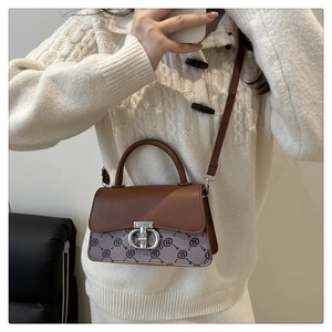 Detail of vintage tote bag showing brown leather texture and silver metal lock