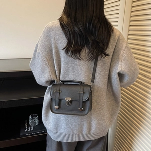 Modische dunkelgraue Messenger Bag als Umhängetasche getragen von einem Modell im Innenraum