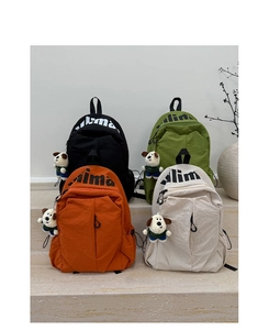 Detalle de cuatro mochilas de nailon impermeables con lindos colgantes de perro felpa