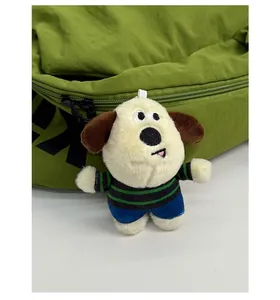 Close-up of cute puppy plush pendant with striped shirt on a large capacity backpack