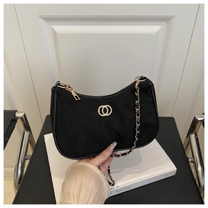 Close-up of black quilted suede underarm bag with gold chain strap and logo hardware