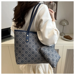 Detail of vintage monogram tote bag and pouch set on office desk lifestyle scene
