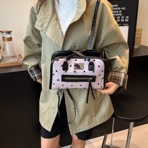 Pink and black butterfly print shoulder bag worn with a stylish khaki trench coat