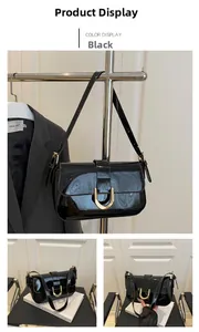 Detail of black patent leather handbag featuring a glossy finish and gold horseshoe buckle