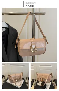 Detailed close-up of khaki patent leather bag with gold horseshoe buckle and strap