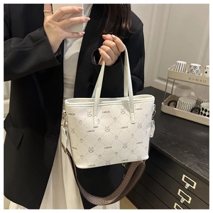 Detail of white quilted tote bag featuring a cute rabbit pattern and wide woven shoulder strap