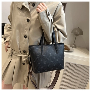Detail of black tote bag featuring cartoon bear jacquard and vintage ethnic wide strap