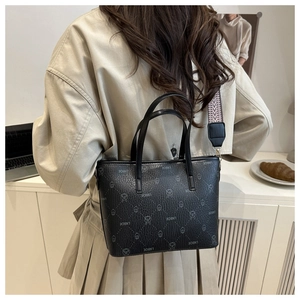 Detailed back view of a black checkered tote bag worn with a patterned shoulder strap