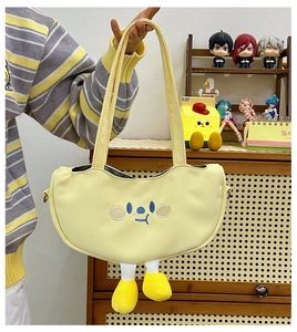 Detail of yellow canvas shoulder bag featuring cartoon embroidery and plush 3D yellow legs