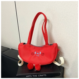 Detail showing the red canvas shoulder bag with cartoon embroidery and plush 3D leg accents