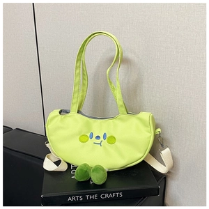 Detail of neon green crescent shoulder bag with cartoon embroidery and pompom accents