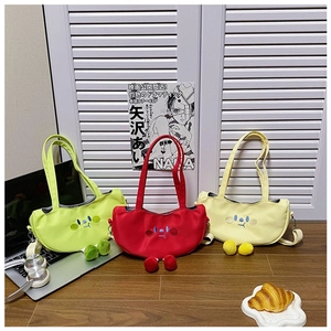 Detail of three cute cartoon tomato canvas crossbody bags in green, red, and yellow colors