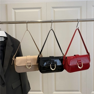 Three glossy patent leather shoulder bags in red, beige and black with metal buckle
