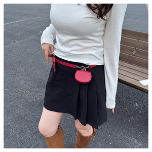Detail of red mini semi-circle waist bag on a skinny belt with stylish outdoor fashion styling