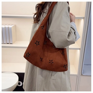 Close-up of brown suede tote bag featuring artistic floral laser-cut detailing and texture