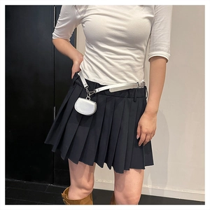 Detail of silver mini waist bag on black pleated skirt with stylish silver belt