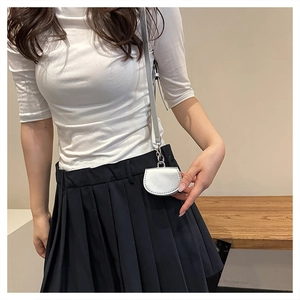 Silver mini crossbody bag shown on a model with a minimalist white tee and navy skirt