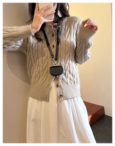 Black mini crossbody bag styled with a beige cable knit cardigan and white dress