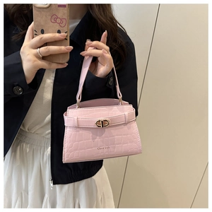 Detail of pink crocodile embossed leather bag with gold-tone circular metal clasp
