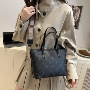 Black checkered tote bag with cartoon print and wide geometric strap shown in lifestyle setting