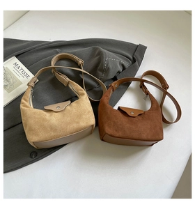 Detail of beige and brown suede hobo bags with adjustable straps in a minimalist setting