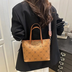 Brown checkered tote bag with patterned strap shown on person in black blazer