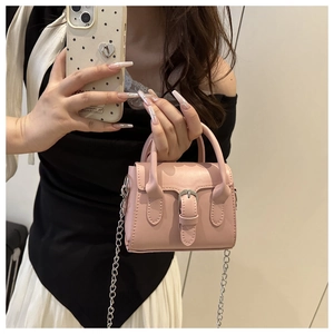 Detail of pink mini leather crossbody bag with silver buckle and chain strap