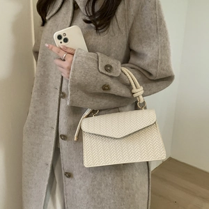 Cream woven texture crossbody bag with knotted handle and golden ring hardware detail