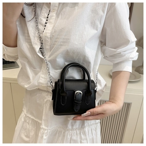 Mini black handbag with silver buckle and thin metal chain strap shown on model