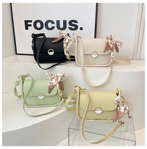 Detail of four colorful crossbody bags with silk scarf accents and magnetic buckles