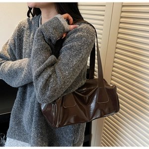 Detailed view of the dark brown glossy baguette bag with premium patent leather texture