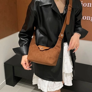 Brown suede textured minimalist half-moon crossbody bag with leather flap and silver hardware