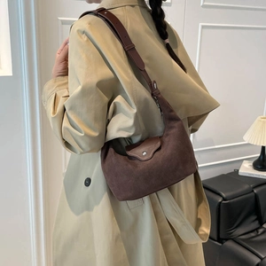 Brown suede faux leather hobo bag with adjustable strap shown on model shoulder