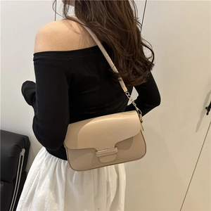 Elegant beige crossbody bag with leather chain strap shown on a model in a minimal setting