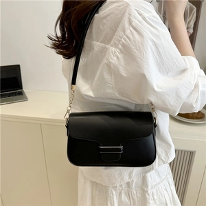 Elegant black minimalist crossbody bag with gold chain strap and sleek metal buckle