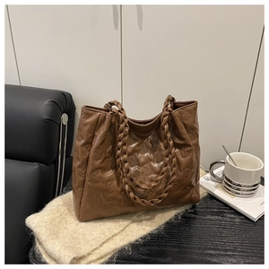 Close-up of embossed bear pattern on dark coffee tote bag with braided handles