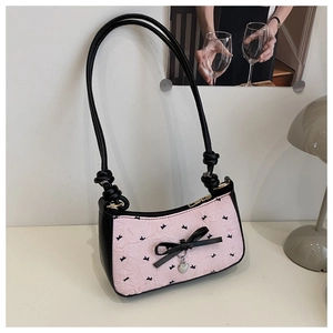 Pink pleated underarm bag featuring a black bow, heart pendant, and butterfly patterns