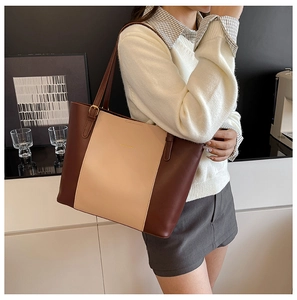 Sac fourre-tout en cuir PU à blocs de couleurs marron et beige sur l'épaule d'un modèle