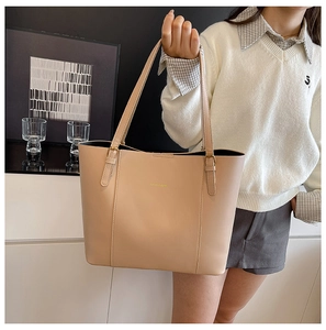 Détails de la boucle dorée et du lettrage de mode sur le sac cabas beige en similicuir