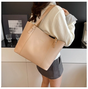Détail du sac cabas en similicuir beige avec texte doré et bandoulières réglables