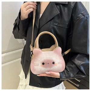Pink plush cat shaped crossbody bag shown with adjustable strap on a model outfit