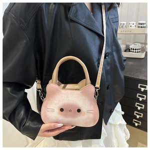 Detailed close-up of pink cat-shaped crossbody bag with smooth stitching and metal buckles