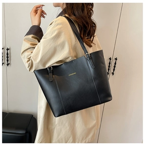 Détail d'un sac cabas en cuir PU noir avec ferrures dorées et lettrage de mode chic