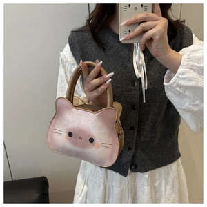 Detail of a mini cat-shaped handbag featuring soft pink gradient and cute cat face print