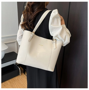 Détail du sac fourre-tout en cuir PU beige avec boucle en métal doré et logo chic