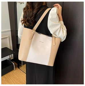 Détail des doubles bretelles et boucles dorées sur un sac cabas en similicuir beige