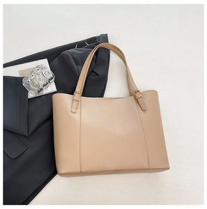 Vue de dessus d'un grand cabas en cuir PU beige avec boucles dorées et bandoulière